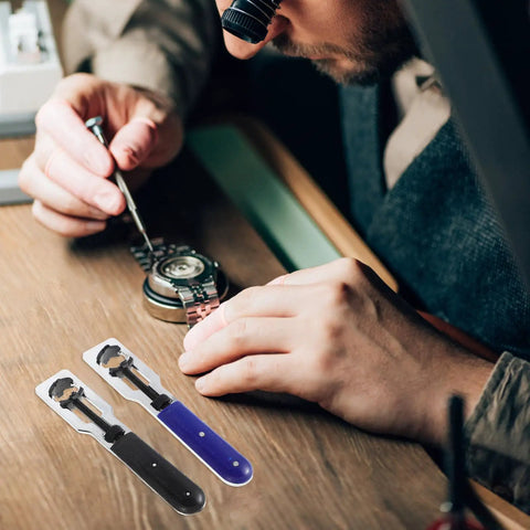 Watch enthusiast using Must Have Dual Function Watch Case Opener And Spring Pin Tool Set for repair on wooden desk