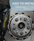 Brake rotor and wheel hub assembly with a black caliper in the background; silver rotor, multiple studs.