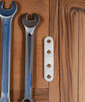 40Pcs Stainless Steel Flat Straight Braces Set next to wrenches on wooden table