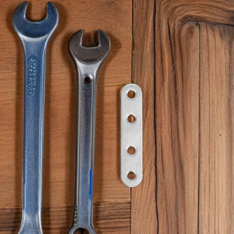 40Pcs Stainless Steel Flat Straight Braces Set next to wrenches on wooden table