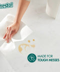 Hand using Ultra-Strong Premium Paper Towels With 158-Sheet 2-Ply Huge Roll, Flex-A-Size Design to clean a spill.