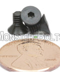 Premium Number Five Forty By Quarter Inch Flat Head Socket Cap Screws With Hex Drive And 82 Degree Countersunk Heads, shown next to a penny.