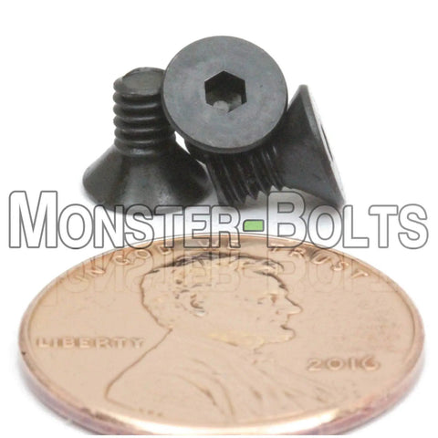 Premium Number Five Forty By Quarter Inch Flat Head Socket Cap Screws With Hex Drive And 82 Degree Countersunk Heads, shown next to a penny.