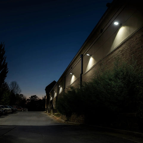 Powerful 12-Watt Waterproof Outdoor Solar Security Light With PIR Motion Sensor And Timer illuminating warehouse exterior at night