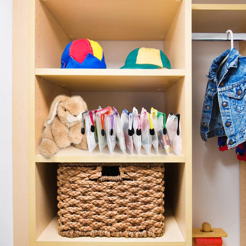 30 Pack Small Zipper Mesh Pouches With Label Pockets, A6 Size 6.3 By 4.7 Inches, shown on a shelf with toys and a jacket