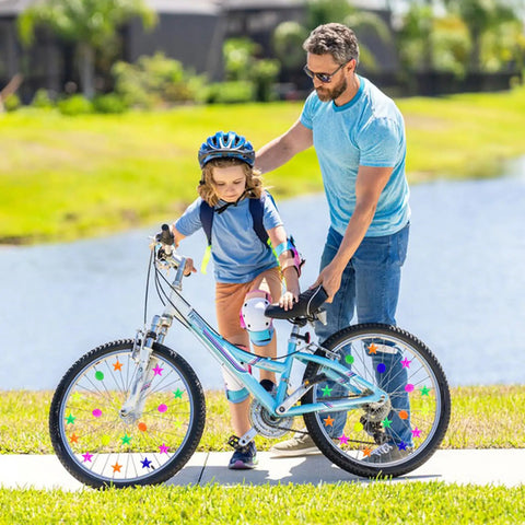 Child riding a bike with Colorful Bike Wheel Spoke Beads Set With Round And Star Shapes, 72 Pieces With Plastic Storage Box Included