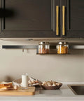 Kitchen scene with 2 Pack Solid Brass Gold Cabinet Pulls With 3 And 3 Quarters Inch Center To Center on dark cabinets above a countertop.