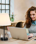 Set of 2 Modern Bedside Lamps With Ivory White Barrel Shade and Sleek Silver Metal Base on a desk with a woman using a laptop