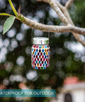 Outdoor Mosaic Lanterns Solar Powered Hanging Lights in mason jar style, suspended from tree branch, colorful mosaic design.