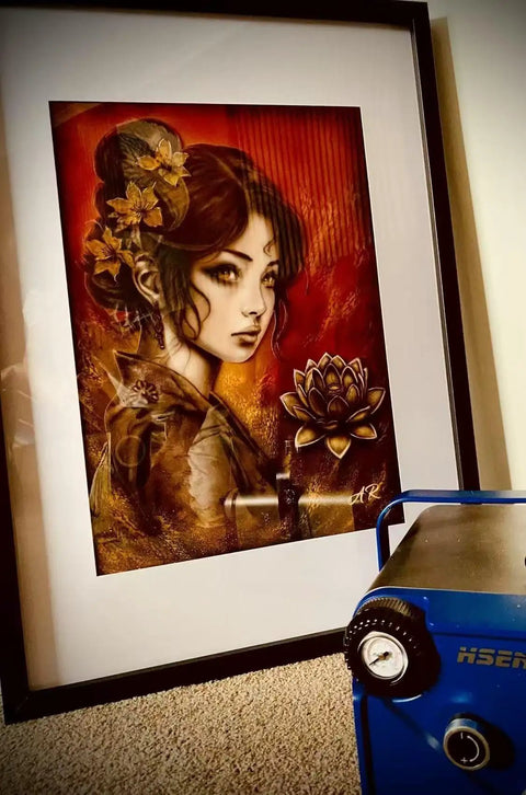 Framed art with a portrait next to an Ultra Quiet Airbrush Compressor With Built In Air Tank Portable Lightweight 5.5lb Unit Integrated Regulator Smooth Air Flow For Hobbyists And Fine Detail Work.