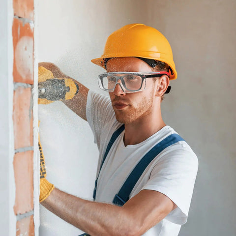 Worker using drill while wearing Over Glasses Safety Goggles With Anti Fog And Scratch Resistant Lenses ANSI Z87 Certified