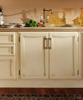 Warm kitchen featuring Six Pack Light Brushed Brass Cabinet Pulls in Zinc Alloy on cream cabinets with modern design hardware.