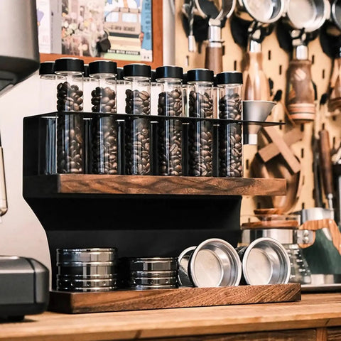 Two Tier Coffee Tool Storage Stand With Twelve Single Dose Bean Vials And One Way Exhaust Valve Plus Heavy Duty Slots For Tamper And Dosing Cups showcasing walnut design and espresso tools.