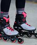 Person wearing Macroblade 90 W Inline Skates for Women in Neutral Grey and Paradise Pink, shown on outdoor surface.