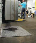 Premium Oil Absorbent Mat Pads 15 x 20 Inches placed on workshop floor absorbing spill near machinery