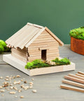 Square Wood Dowels Quarter Inch by 12 Inch 25 Pack Unfinished Craft Sticks used to build a miniature wooden house with moss.