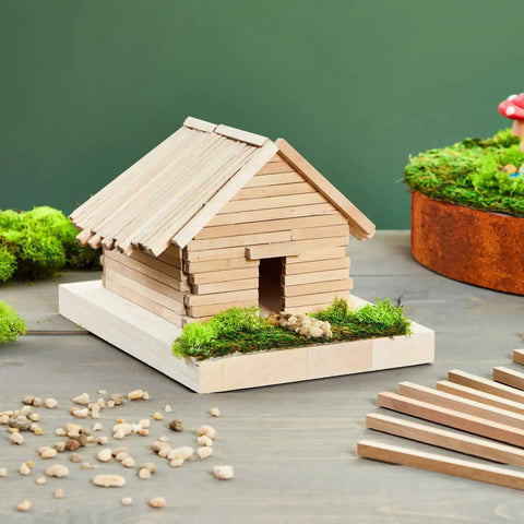 Square Wood Dowels Quarter Inch by 12 Inch 25 Pack Unfinished Craft Sticks used to build a miniature wooden house with moss.