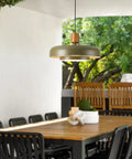 Mid Century Pendant Light 19 Inch Chandelier Featuring Bold Deep Green Shades Paired With Sleek Natural Wood And Polished Brass Accents in outdoor dining area.