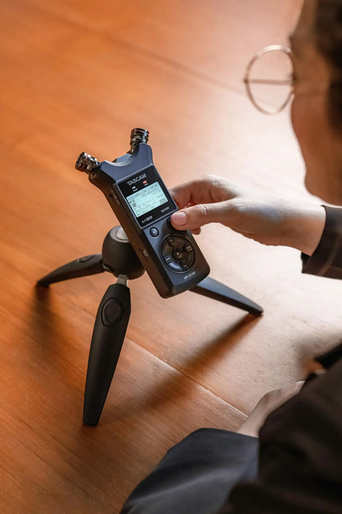 Pro On The Go Grab And Go 32 Bit Float Field Recorder With USB C Audio Interface on tripod, user adjusting settings