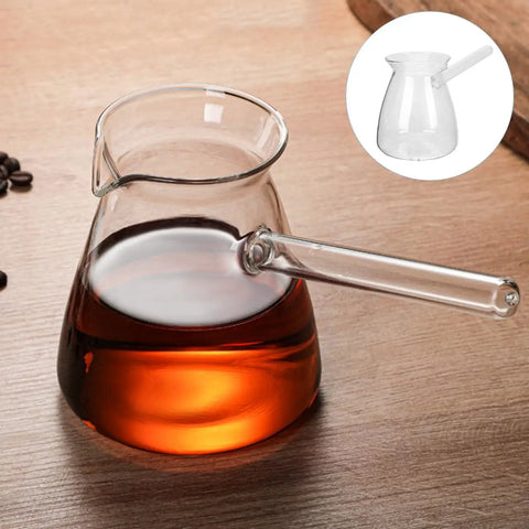 Glass coffee pot with side handle on wooden table, filled with coffee. Inset image of empty pot.