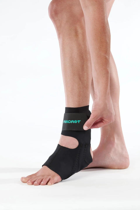 Person adjusting Airheel Ankle Support With Stabilizers For Fast Swelling Relief And Better Circulation on left foot.