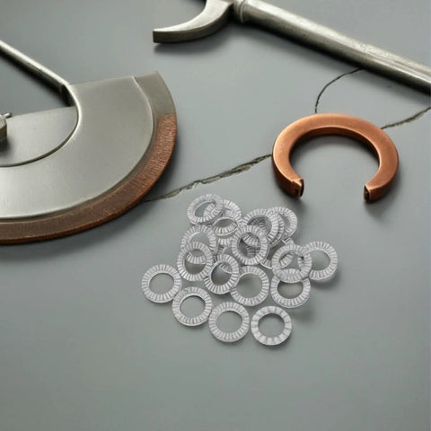 Get Your Garage Ready With These Beefy M10 Manganese Steel Wedge Locking Washers 30 Pairs Set on a work table, various tools visible.