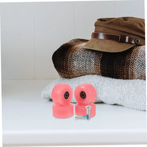 Pink wheels and metal screws from 18 Pack Roller Skate Brake Screws And Stopper Fittings For Inline And Quad Skates, on fabric surface.