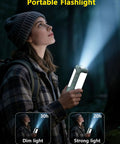 Person using Rechargeable 3-In-1 Camping Lantern With Foldable Tent Light And Handheld Flashlight, 1500LM, 10000mAh Power Bank, in forest.