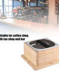 Top Shelf Stainless Steel Coffee Knock Box With Solid Wood Base Massive Grounds Bin at a coffee shop counter.