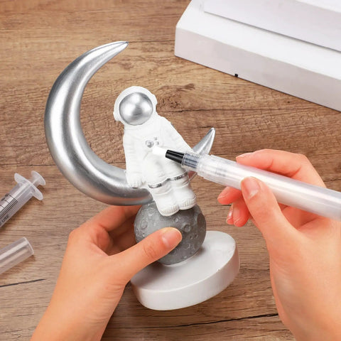 Using Five Pack Touch Up Paint Pens For Walls Fillable And Refillable Reusable Wall Repair Tools to paint astronaut figurine.