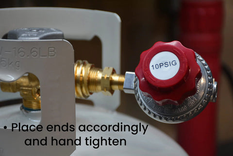 Propane regulator with red knob labeled 10PSIG, brass fittings, connected to a propane tank.