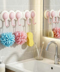 Heavy Duty Six Hook Adhesive Wall Rack With Smooth 180 Degree Swivel And Easy No Drill Mount, pink hooks holding bath accessories.