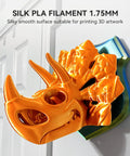 Orange 3D-printed dragon head sculpture with glossy silk finish on a blue-green pedestal.