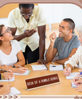 Desk Of A Humble Genius Funny Desk Sign With Aluminum Frame on table during team meeting, 8 x 2.4 inch size, gold color.