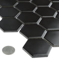 2-Inch Hex Matte Black Porcelain Mosaic Tile For Floors And Walls Mesh Mounted 11.13 x 12.63 Inches with coin for scale.