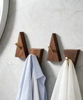 Solid Black Walnut Triangle Wall Hooks With Brushed Brass Caps, Heavy Duty Entryway Coat Rack holding shirts.
