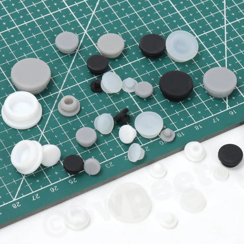 Massive Set Of 120 White Rubber Plugs In 9 Sizes For Round Holes, Heavy Duty Silicone Snap Locking Stopper Kit Perfect For Furniture Repair And DIY Projects Around The House., assorted white and black silicone hole plugs in multiple sizes on cutting mat