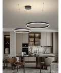 Modern Large Black Aluminum Circle Pendant Light Sleek Ceiling Lamp For Living Room And Kitchen Dining, two rings above a dining table.