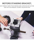 Front view of two metal DC motor mounting brackets with gear housing and drive shafts on a workbench