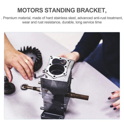 Front view of two metal DC motor mounting brackets with gear housing and drive shafts on a workbench