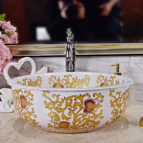 Slick White Ceramic Vessel Sink For Above Counter Bathroom Vanity With Top Shelf Glossy Glaze And Dead Simple Cleanup Round Art Bowl Shape Durable Porcelain with gold floral design.