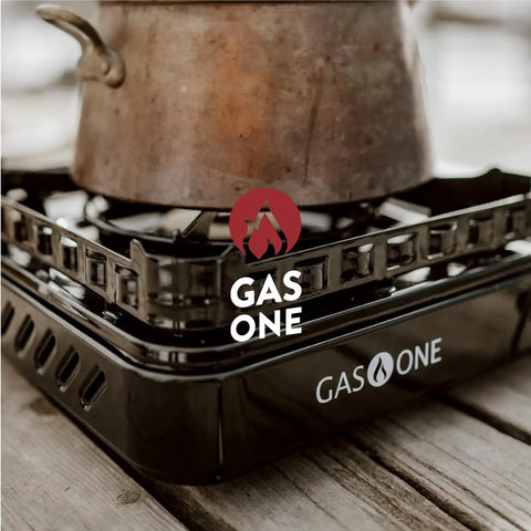 Close-up of a pot on a 15,000 BTU Dual Fuel Portable Camping Stove For Propane Or Butane, outdoor cooking gear on wood surface.