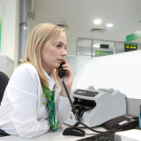 Bank employee with Money Counter Machine With Value Count And Counterfeit Detection UV MG IR Large LCD Display at desk