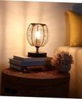 Khaki Rattan Pendant Lamp Shade With Hollow Basket Design for cozy living room ambiance, natural glow with books and plant decor