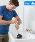 Man using Six Pack Heavy Duty Black Toilet Plungers Featuring Solid Wood Handles And Beefy Rubber Cups in a sink.