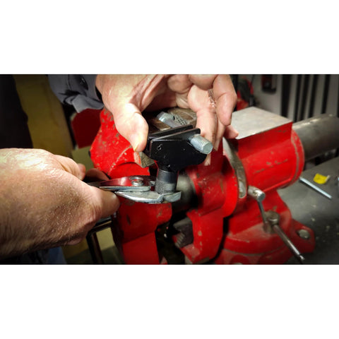 Powerbuilt universal thread repair tool in use; repairing damaged bolt threads in a red bench vise.