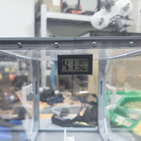 Close-up of a temperature and humidity monitor for 3D printers DIY friendly hygrothermograph kit in a box enclosure.