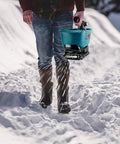 Person using Handheld Seed Spreader For Makita 18V Battery Lawn Fertilizer And Salt Ice Melt Spreader Year Round Use For Grass Seed Fertilizer Rock Salt And Ice Melt Battery Not Included on snowy path