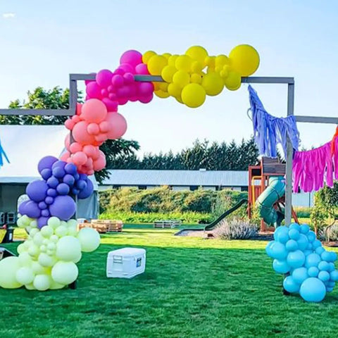 Rainbow Balloon Arch Kit With 80 Latex Balloons in 12 and 10 Inch Sizes Dope Neon Purple Teal Hot Pink Light Blue Light Green Matte Yellow and Lemon Hues Perfect Pool Party Vibes for Tropical Theme Carnival Decor for Kids Birthday creating vibrant arch over outdoor grass area