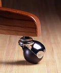 2-Inch Office Chair Caster With Soft Black Rubber Ball, Chrome Hooded Swivel, installed on a wooden furniture leg